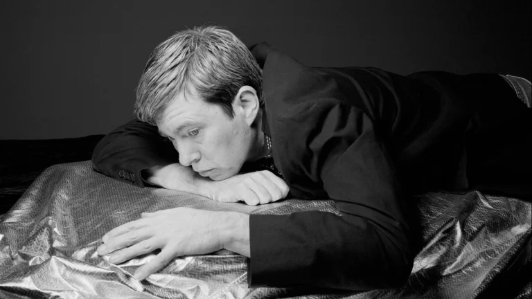 Black and white portrait of Bill Callahan resting on a metallic sheet