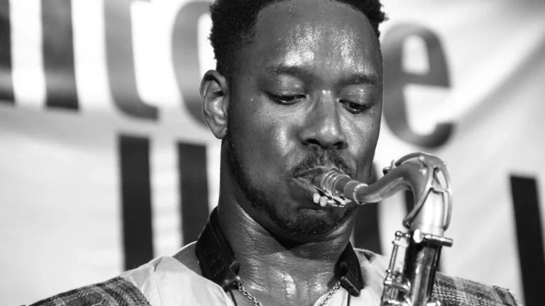 Black and white close-up of Shabaka Hutchings playing the saxophone