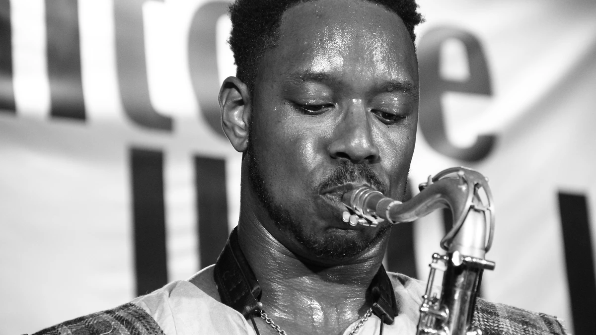 Black and white close-up of Shabaka Hutchings playing the saxophone
